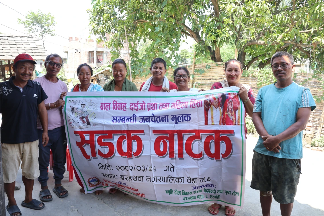 Members of the Smriti Tole Committee showing a poster of the street drama they conducted